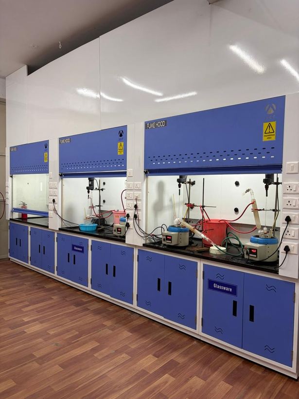 Row of fume hoods along the synthesis laboratory wall, reactions set up under each