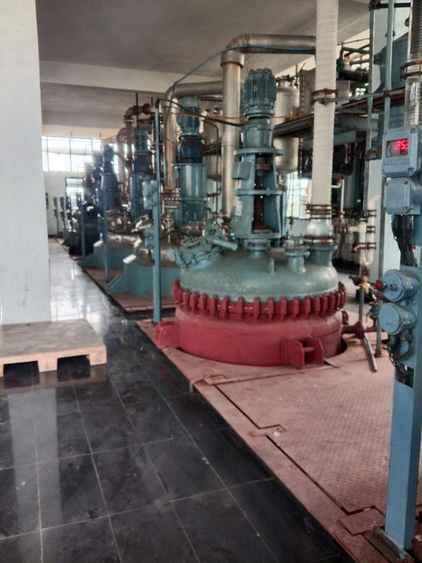 Glass-lined reactor with agitator drive and temperature controller in the production bay